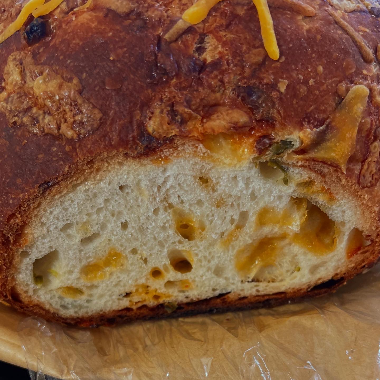 Cheese artisan loaf showing its golden crust and open crumb