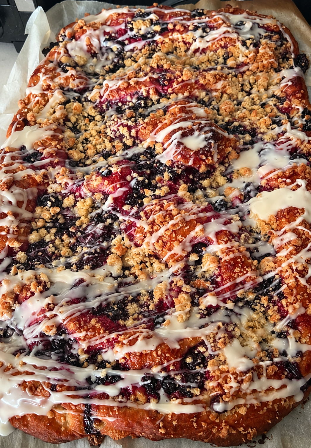 Fresh-baked berry cobbler with crumb topping and glaze